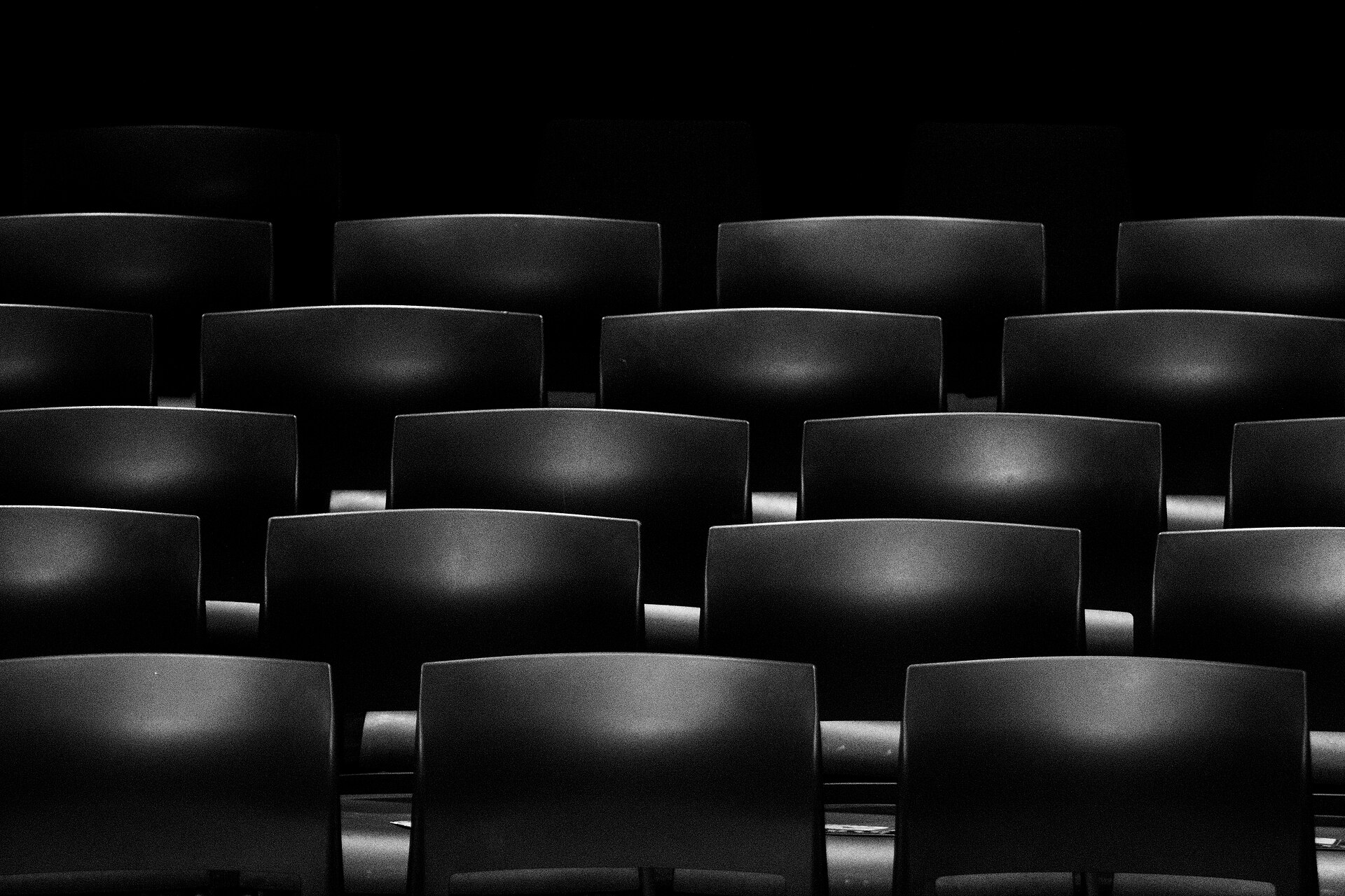 Rows of empty cinema seats receding into a dark auditorium